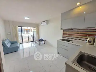 Modern open-layout living room with sleek kitchen and balcony access