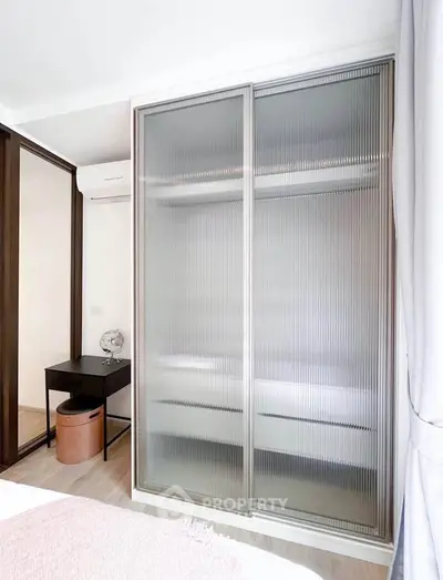 Modern bedroom with frosted glass wardrobe and sleek desk setup