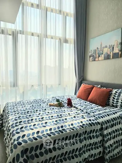 Bright bedroom with large windows and modern decor in a high-rise apartment.