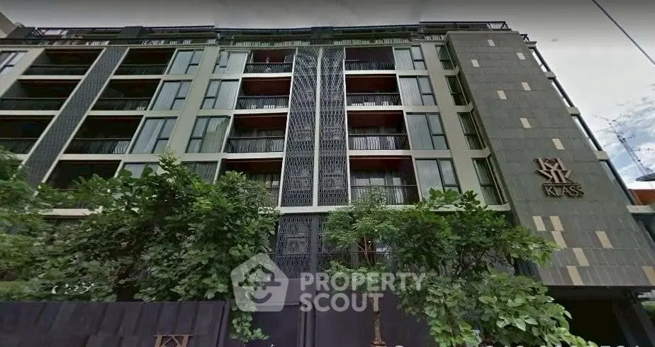 Modern urban apartment building with stylish facade and lush greenery