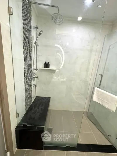 Luxurious modern bathroom with glass shower and sleek tile design