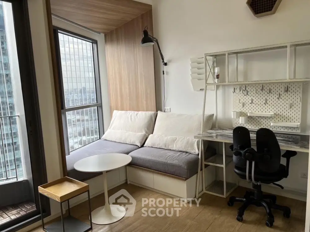 Modern minimalist living room with ample natural light, comfortable seating, and a dedicated workspace, perfect for urban living.