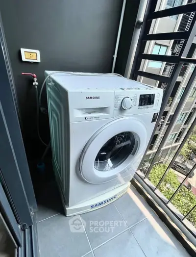 Modern washing machine on a balcony with city view, perfect for urban living convenience.