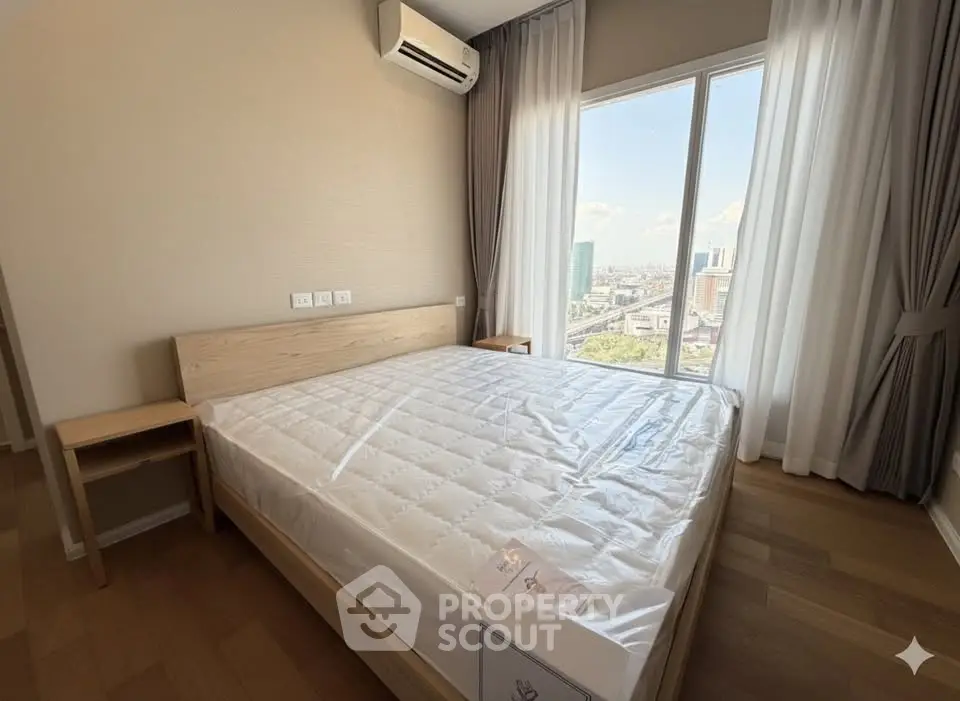Modern bedroom with large window offering city view, featuring a comfortable bed and air conditioning.