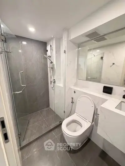 Modern bathroom with glass shower and sleek fixtures in a contemporary apartment.