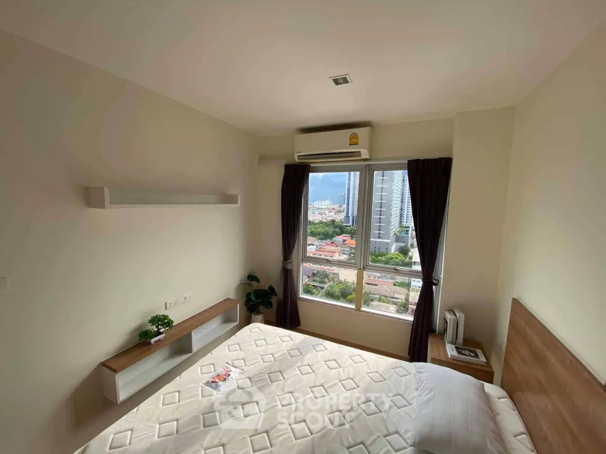Bright bedroom with city view, featuring a large window and modern air conditioning unit.