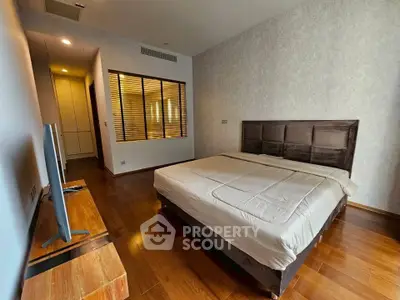 Spacious modern bedroom with wooden flooring and stylish decor
