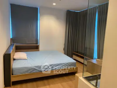 Modern bedroom with wooden flooring and large windows, featuring a minimalist design and cozy ambiance.