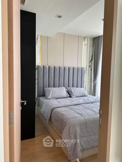 Modern bedroom with stylish decor and large window for natural light.