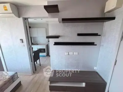 Modern apartment interior with stylish shelving and compact kitchen area.