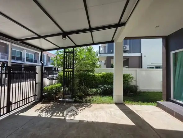 Modern house exterior with covered patio and lush greenery