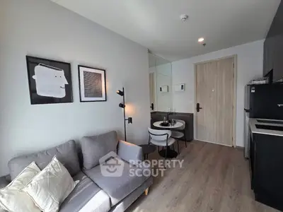 Modern living room with stylish decor and compact dining area in a cozy apartment.