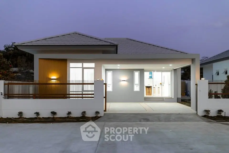 Modern single-story house with sleek design and spacious driveway at dusk.
