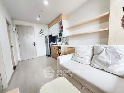 Modern living room with cozy sofa and open kitchen layout in a stylish apartment.