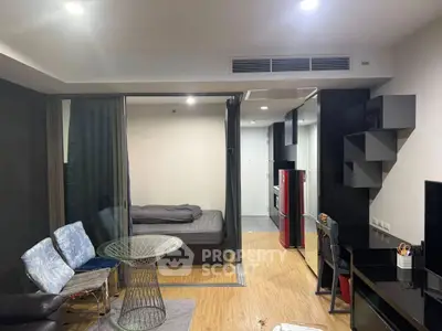Modern studio apartment with open layout, featuring a cozy living area and sleek kitchen design.