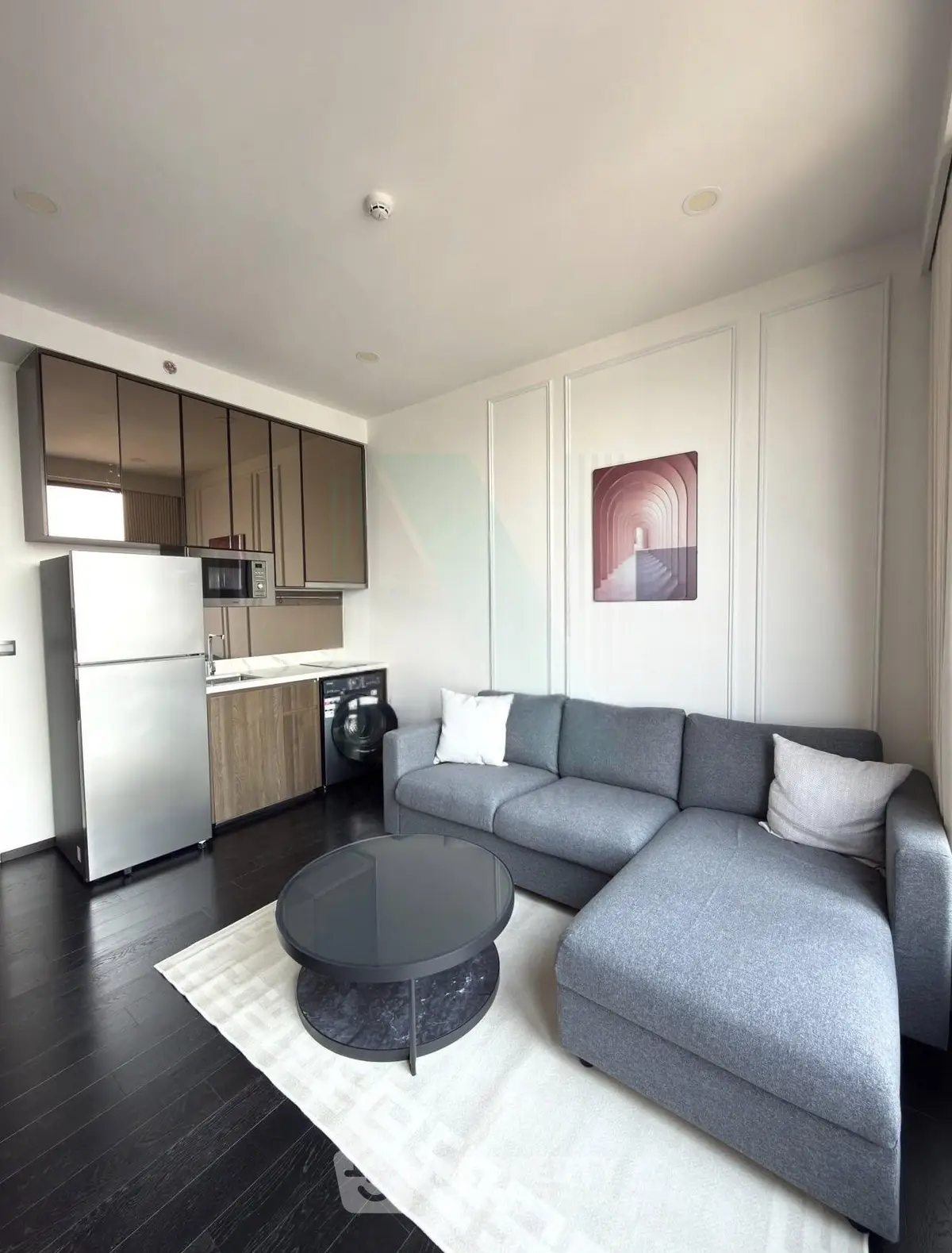 Modern living room with sleek kitchen, stylish sofa, and contemporary decor in a chic apartment.