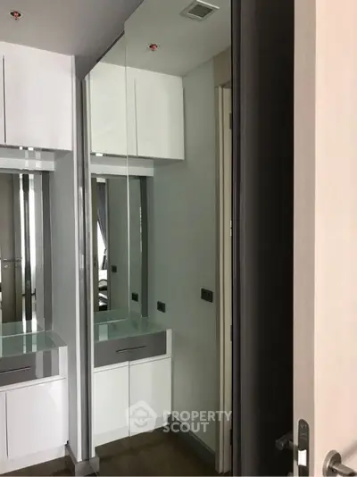 Modern interior with sleek mirrored closet doors and contemporary design.