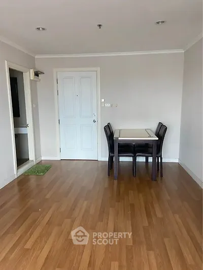 Spacious living room with wooden flooring and dining area in modern apartment.