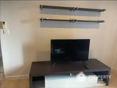 Modern minimalist living room with sleek wall-mounted shelves and a stylish TV stand, perfect for cozy entertainment.