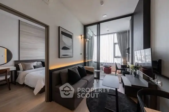 Modern living room with sleek furniture and adjacent bedroom, featuring large windows and stylish decor.