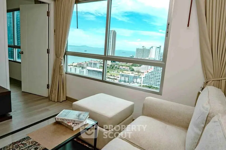 Stunning living room with panoramic city and ocean views, featuring elegant decor and cozy seating.