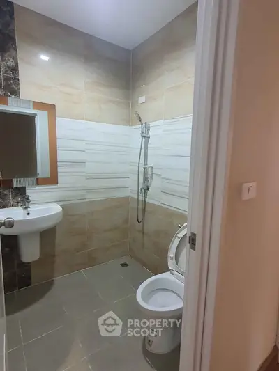 Modern bathroom with sleek tiles and contemporary fixtures in a stylish apartment.