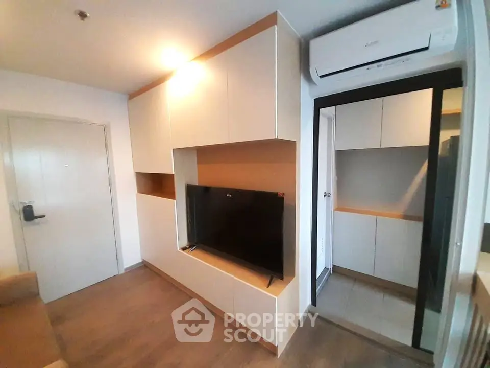 Modern living room with built-in TV unit and air conditioning, showcasing sleek design and functionality.