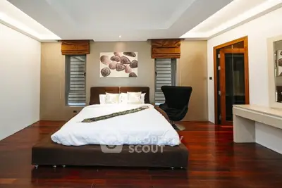 Luxurious bedroom with modern decor and hardwood floors in upscale property.