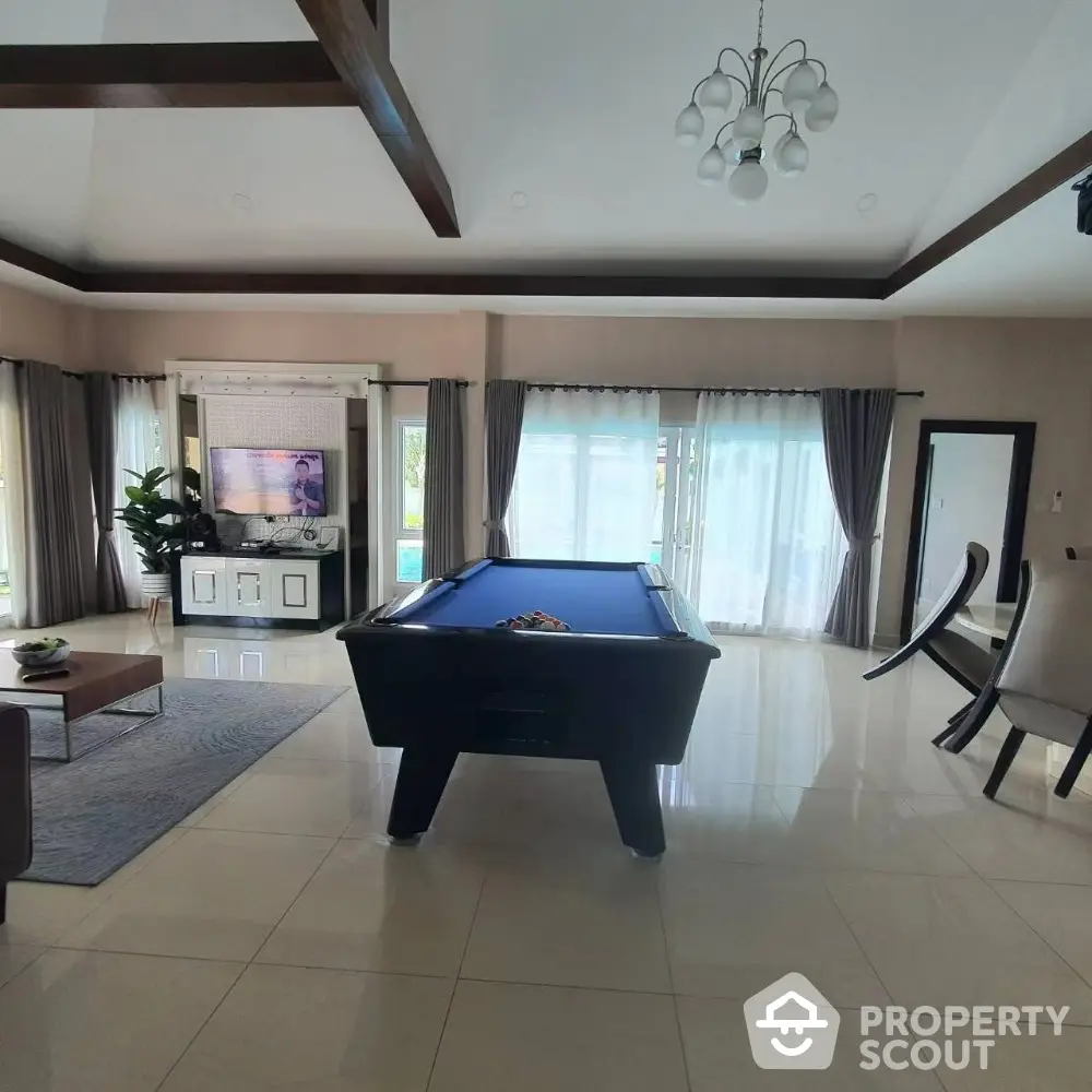 Spacious living room with pool table and modern decor, perfect for entertainment and relaxation.