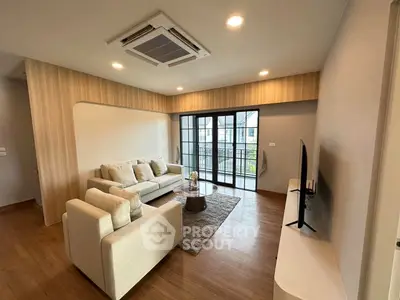Modern living room with stylish furniture and large windows offering natural light and a cozy atmosphere.