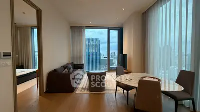 Modern living room with city view, featuring elegant furniture and large windows.