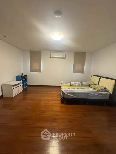 Spacious bedroom with wooden flooring and modern minimalist decor