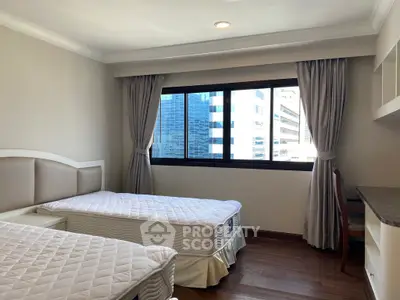 Spacious bedroom with twin beds and city view, perfect for urban living.