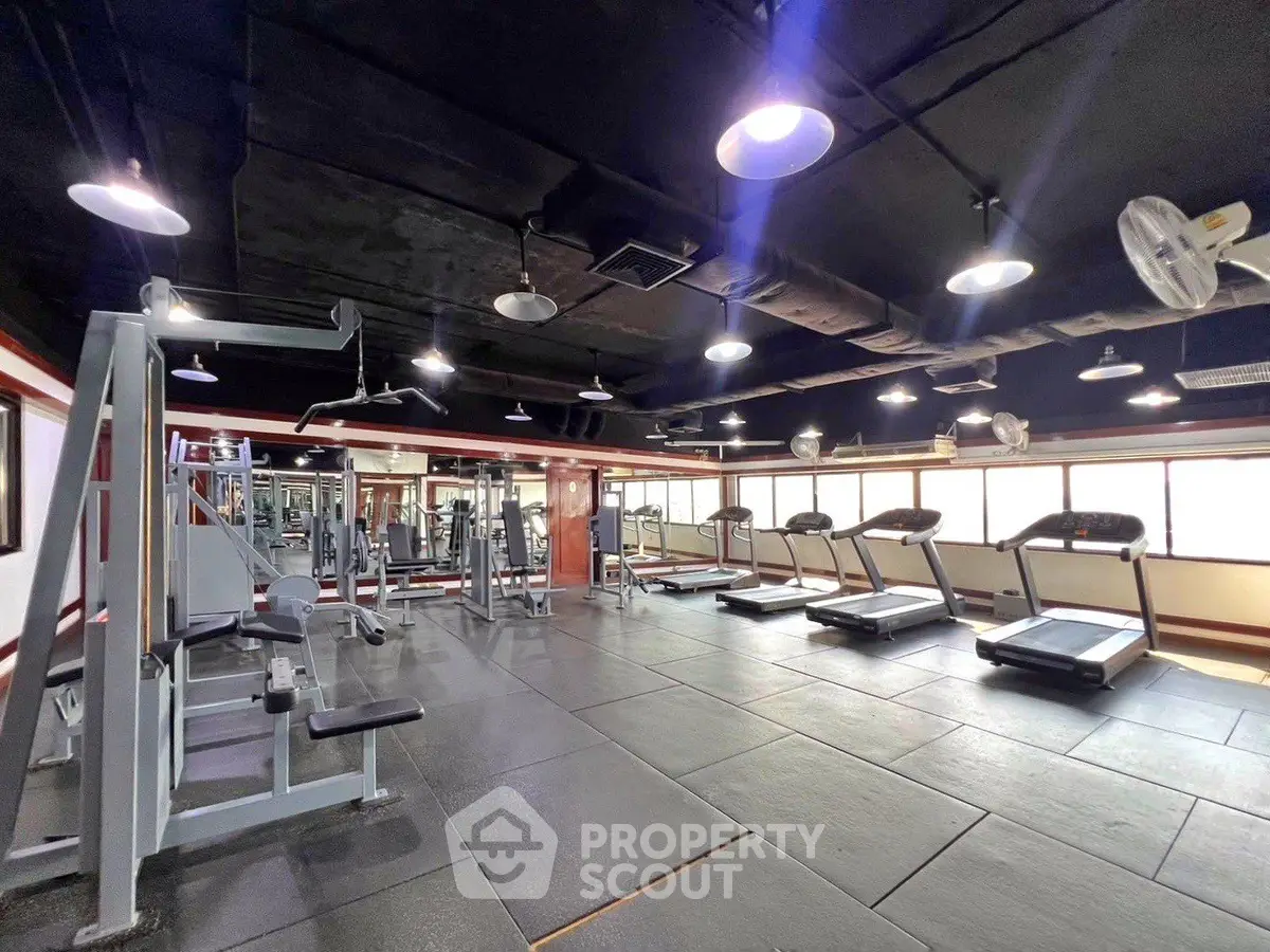 Spacious modern gym with state-of-the-art equipment and ample natural light.