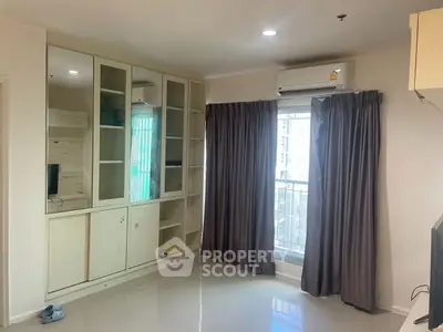 Modern living room with built-in storage and large window with city view.