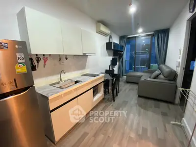 Modern open-layout kitchen and living area with sleek design and cozy ambiance.