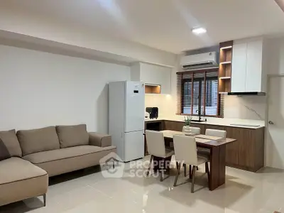 Modern open-plan living room and kitchen with sleek furniture and appliances.
