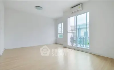 Spacious empty room with large windows and wooden flooring, perfect for customization.