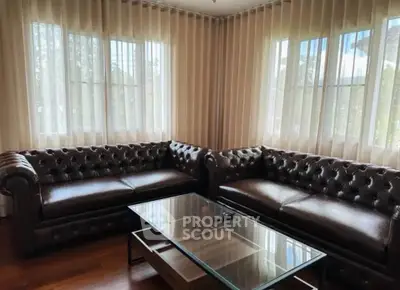 Elegant living room with leather sofas and glass coffee table in natural light