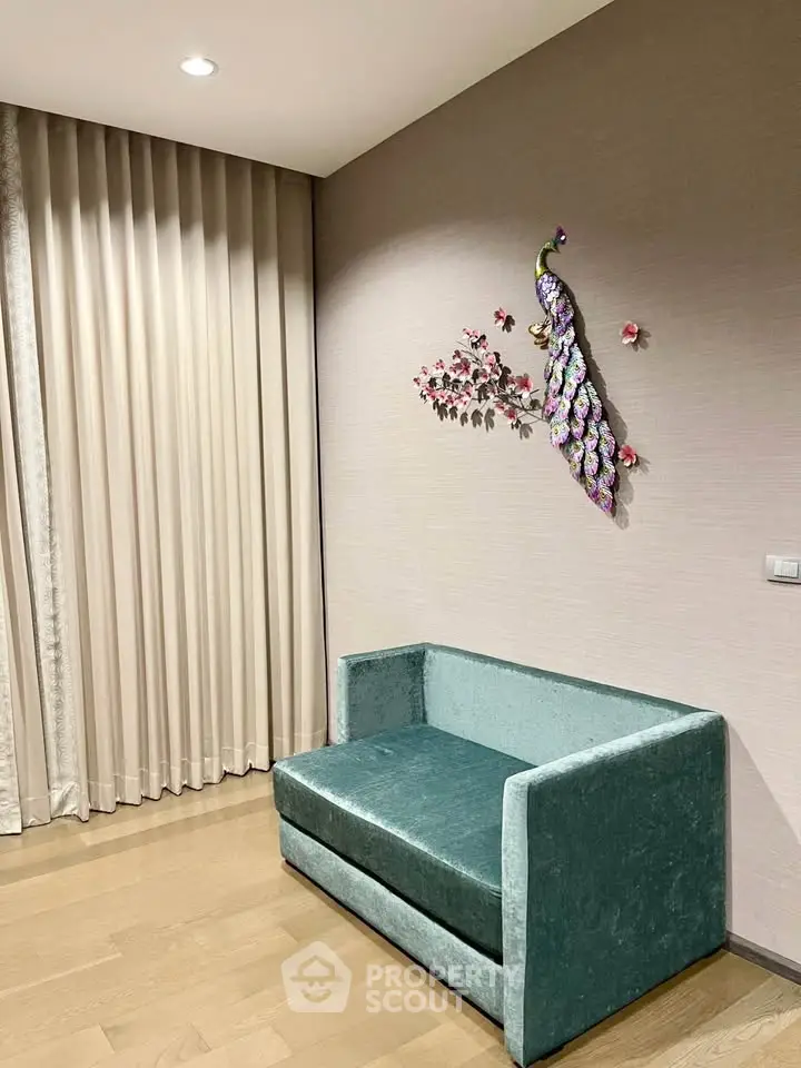 Elegant living room corner with teal sofa and peacock wall art, perfect for modern interiors.