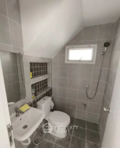 Modern bathroom with sleek gray tiles and compact design