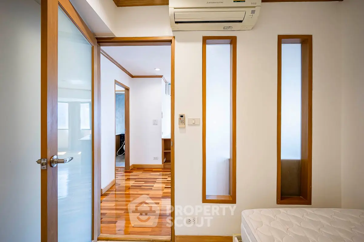Modern bedroom with wooden accents and air conditioning unit