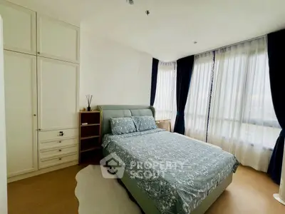 Spacious bedroom with elegant decor and large windows for natural light