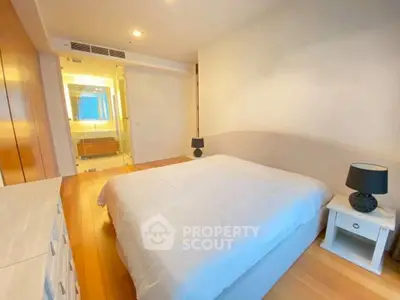 Spacious bedroom with ensuite bathroom in modern apartment