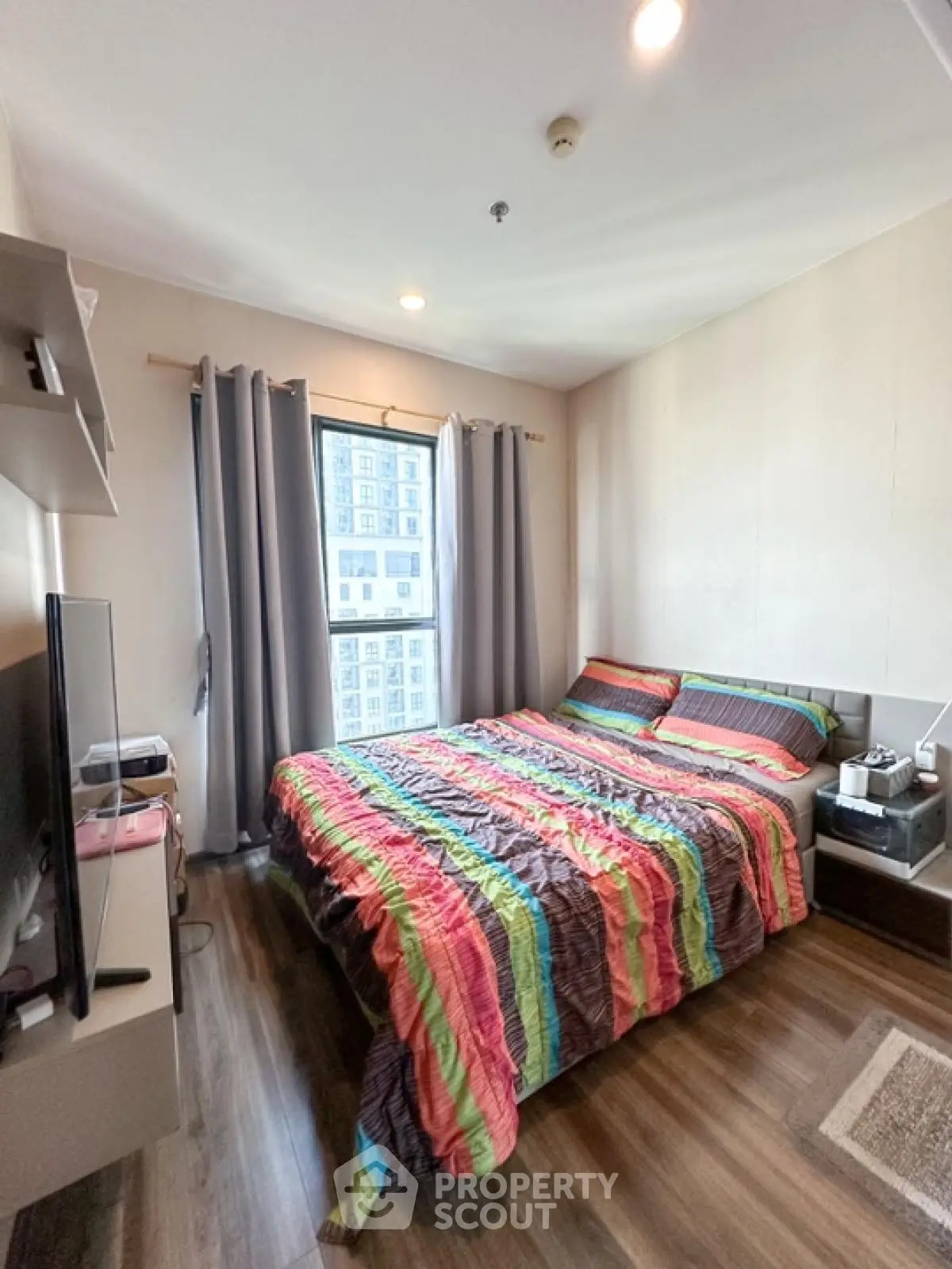 Cozy bedroom with colorful bedding and modern decor in a high-rise apartment