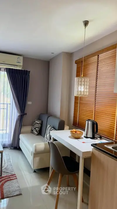 Modern living room with cozy sofa, dining table, and balcony view in a stylish apartment.