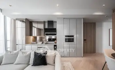 Modern open-concept living room with sleek kitchen design and cozy seating area.