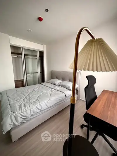 Modern bedroom with sleek design, featuring a cozy bed and stylish workspace.