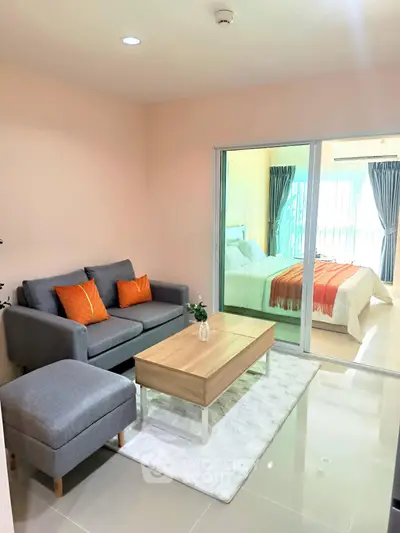 Modern living room with cozy sofa and stylish decor adjacent to a bright bedroom.