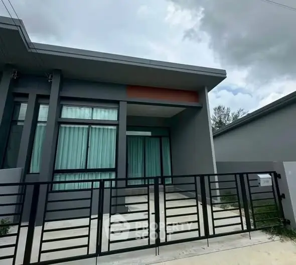 Modern single-story house with sleek design and gated entrance